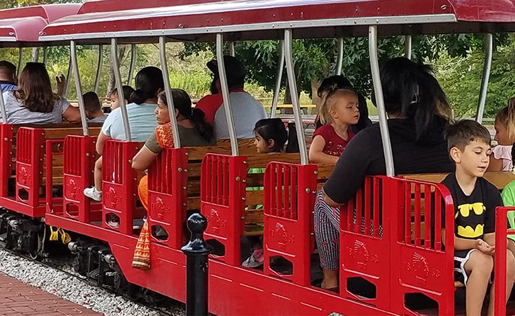 Passengers riding a miniature train at Blackberry Farm